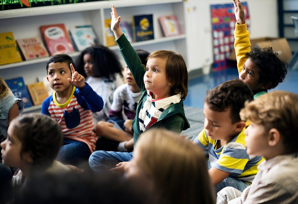 Children in a classroom raise their hands, eagerly participating in a lesson or discussion.