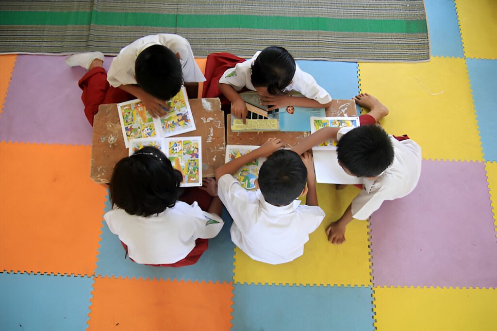 A group of children joyfully playing on a vibrant, colorful floor, engaging in various activities together.